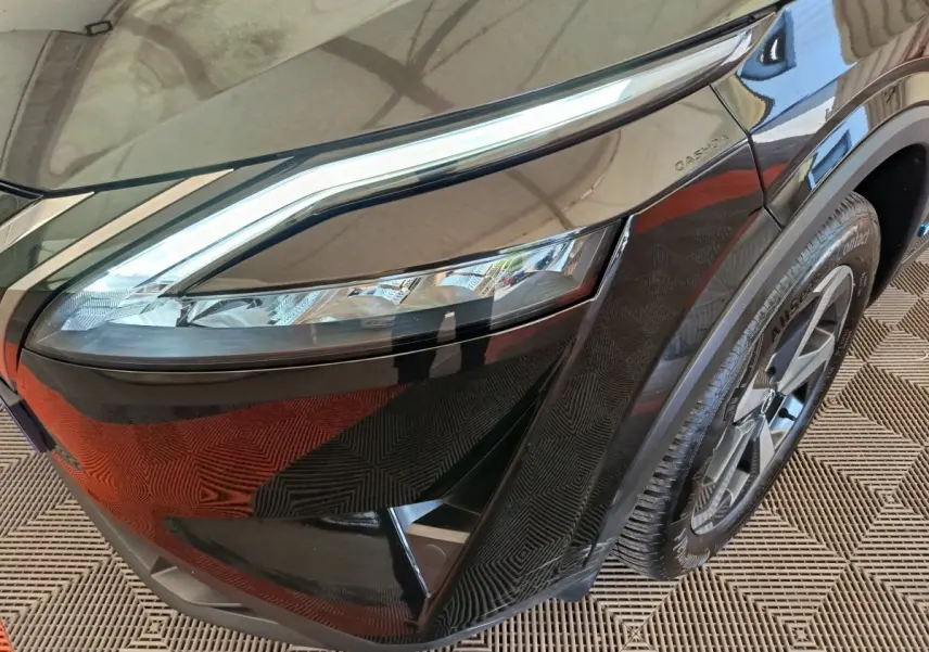 Gros plan sur l'avant droit noir du Nissan Qashqai e-Power 190 avec phare LED et jante alliage visible.