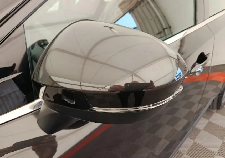 Gros plan sur le rétroviseur côté conducteur noir brillant du Nissan Qashqai e-Power 190 Business Edition 2024.