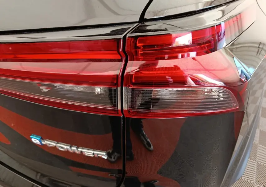Gros plan sur le feu arrière droit et le logo e-Power du Nissan Qashqai noir 2024, finition Business Edition.