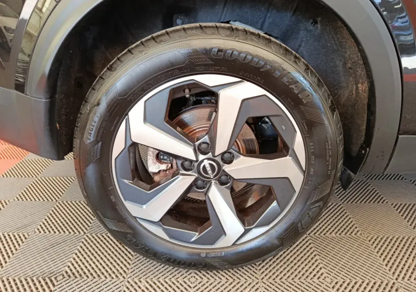 Gros plan sur la roue avant droite du Nissan Qashqai e-Power 190 Business Edition noire avec jante alliage bicolore.
