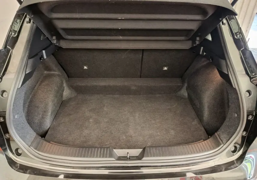 Coffre ouvert noir du Nissan Qashqai e-Power 190 Business Edition BVA, vue arrière montrant l'espace de chargement vide.