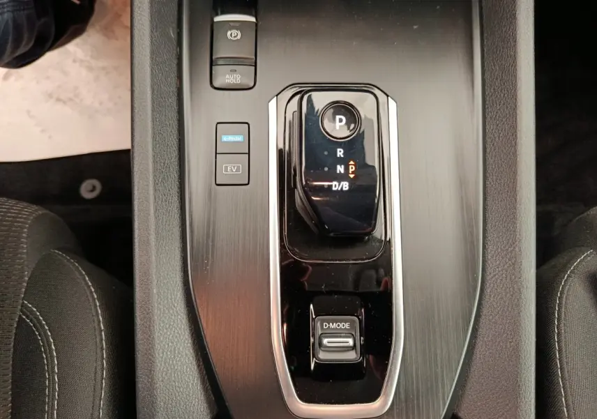 Vue rapprochée de la console centrale du Nissan Qashqai e-Power 2024, avec sélecteur de vitesse noir brillant et boutons de mode.