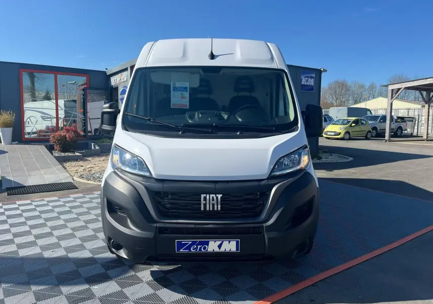 Vue frontale d'un FIAT Ducato Fourgon blanc 2023 avec calandre noire et logo FIAT bien visible.