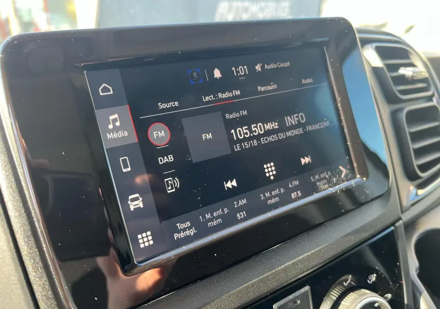 Écran tactile central du tableau de bord du Fiat Ducato Fourgon blanc, affichant la radio FM à 105,50 MHz.