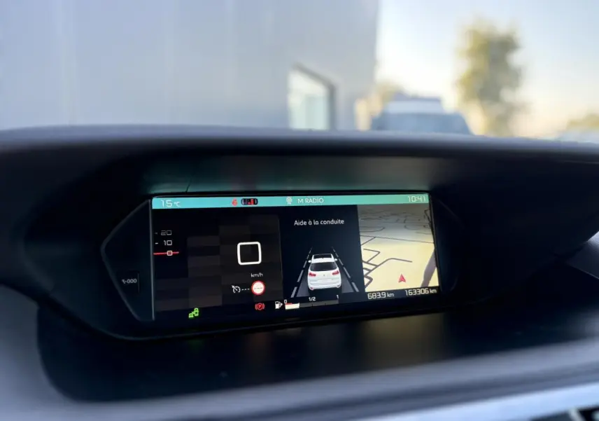 Écran panoramique du tableau de bord montrant l'aide à la conduite et la navigation du Citroën C4 Picasso gris Platinium.