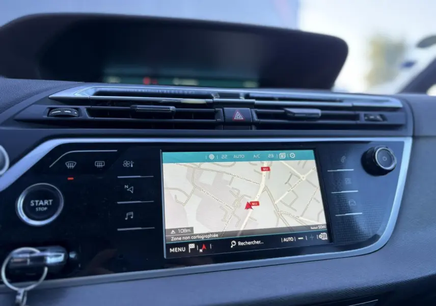 Tableau de bord de Citroën C4 Picasso gris Platinium de 2017 avec écran tactile GPS affichant une carte en navigation.
