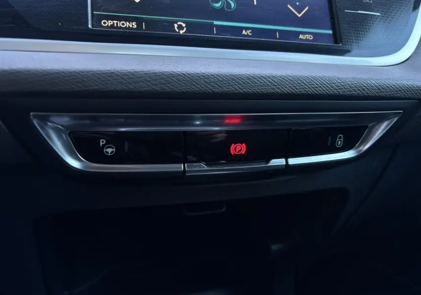 Gros plan sur la console centrale du Citroën C4 Picasso 2017 montrant le frein de stationnement électrique actif.
