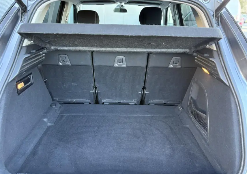 Coffre spacieux ouvert de Citroën C4 Picasso gris Platinium, montrant la tablette cache-bagages et les sièges arrière rabattables.