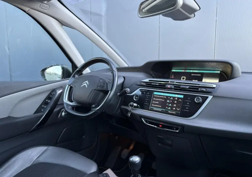 Intérieur de la Citroën C4 Picasso 2017 côté conducteur, tableau de bord noir avec écran tactile et volant cuir.