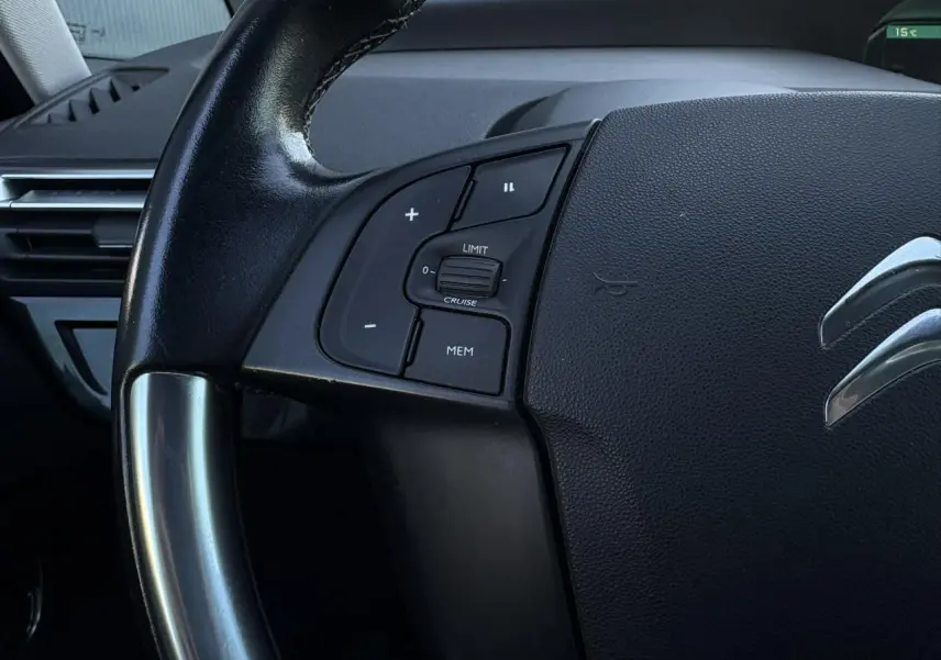 Gros plan sur le volant cuir noir de la Citroën C4 Picasso 2017 avec commandes de régulateur de vitesse côté gauche.