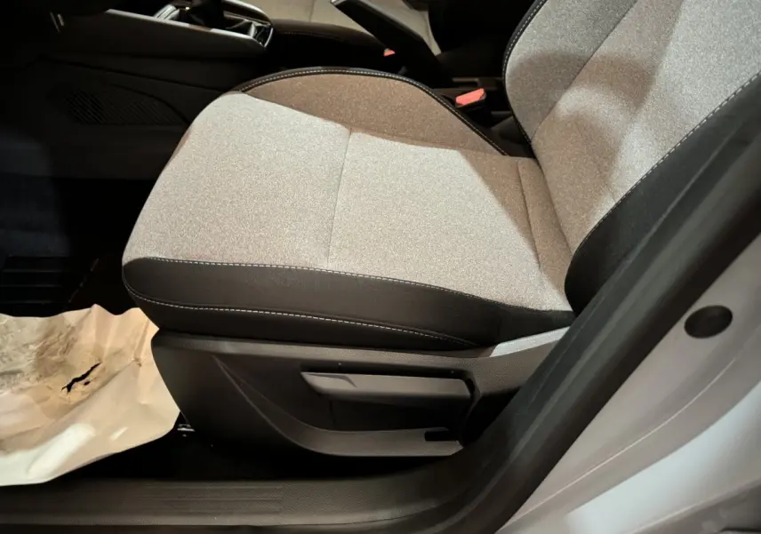 Gros plan sur le siège avant droit gris clair de la Renault Clio Evolution Blue dCi 100 -25 avec détails de la manette de réglage.