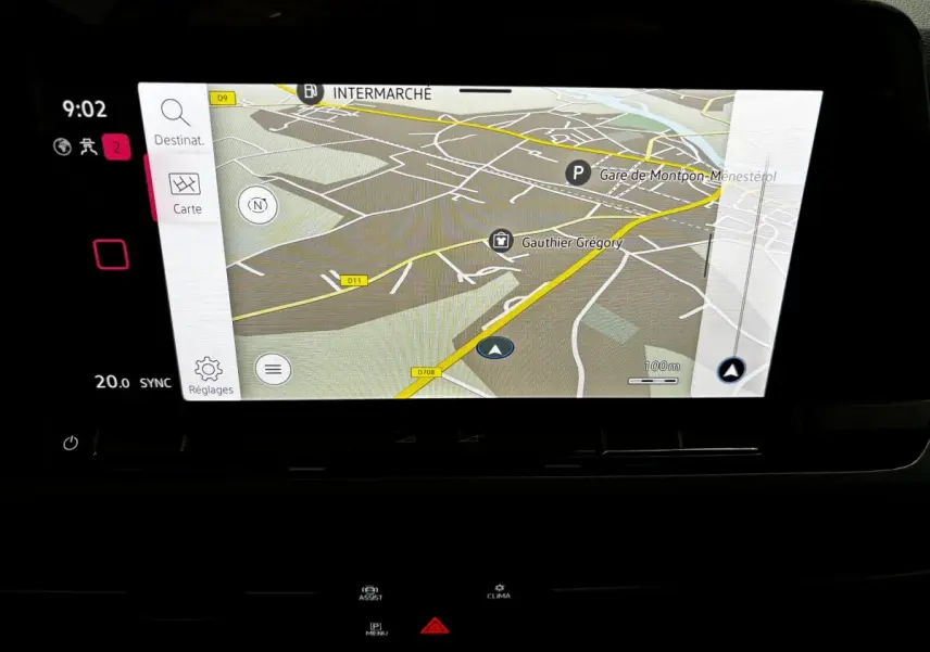 Écran tactile central de navigation du Volkswagen Golf noir 2024, affichant une carte détaillée avec options et réglages visibles.
