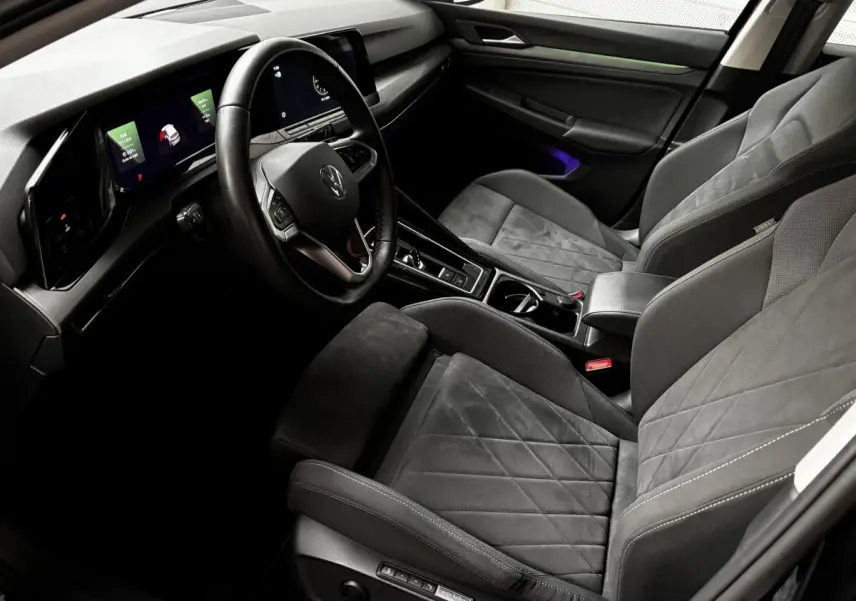 Intérieur gris foncé de la Volkswagen Golf 2024, vue côté conducteur, avec tableau de bord digital et volant cuir multifonctions.