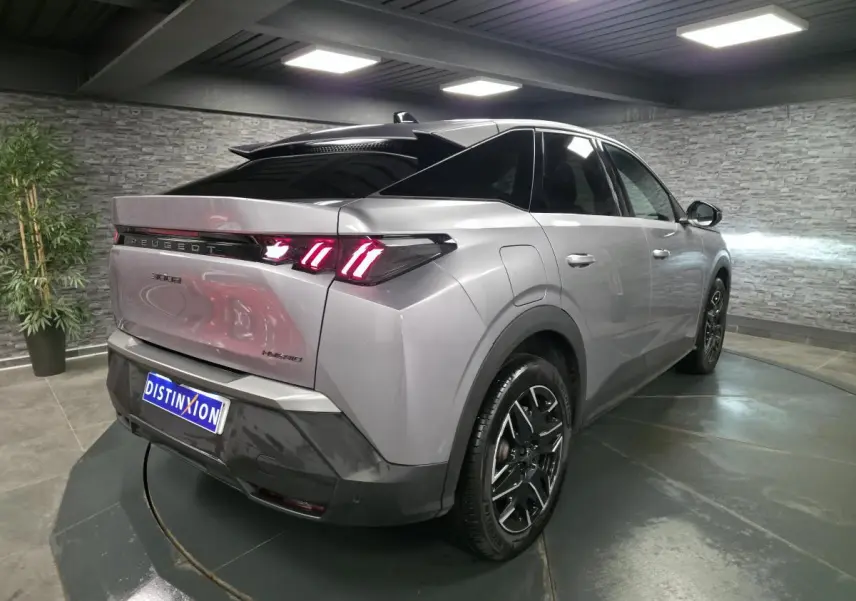 Vue 3/4 arrière droite d’un Peugeot 3008 gris métallisé avec feux arrière LED en forme de griffes et jantes alliage noires.