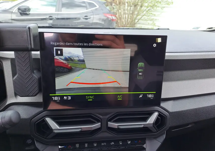 Vue intérieure du tableau de bord du Dacia Bigster 2026, écran affichant la caméra de recul avec guidage coloré.