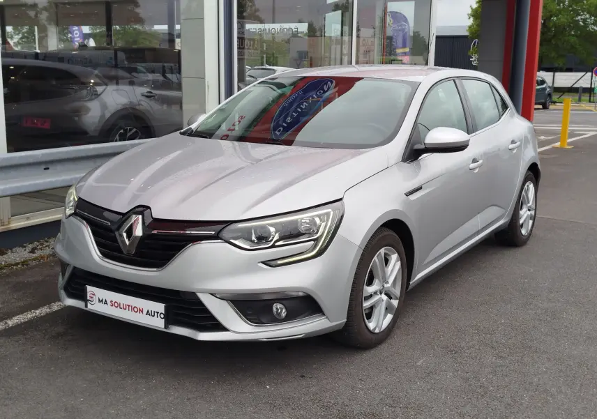 Renault Mégane gris titanium vue 3/4 avant droit, avec phares LED et calandre noire brillante.