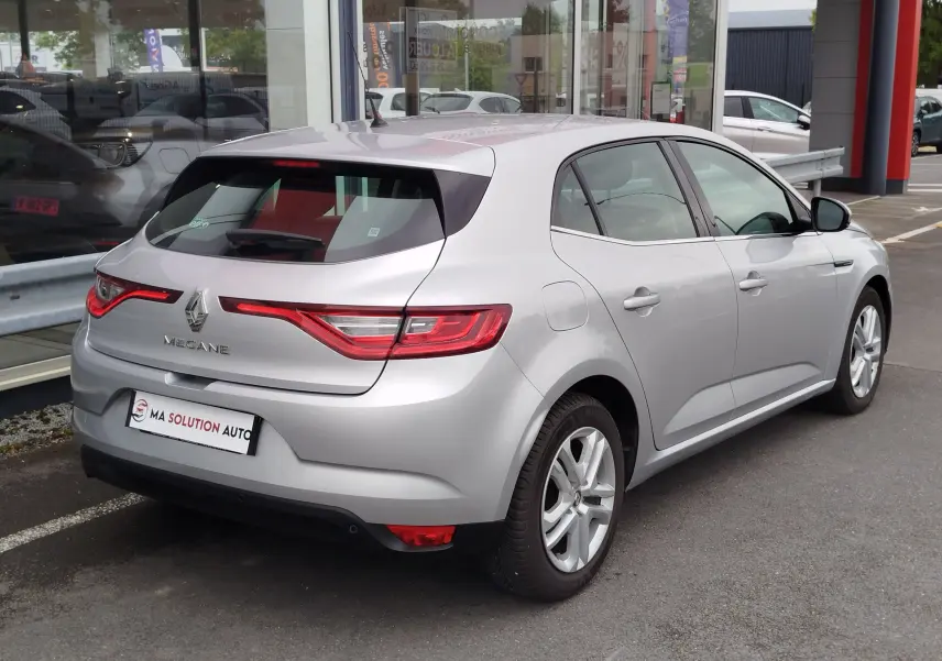 Vue 3/4 arrière droite d'une Renault Mégane gris titanium de 2018, avec feux arrière LED et jantes alliage visibles.