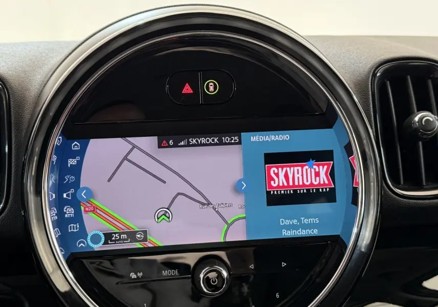 Écran tactile central rond du tableau de bord du MINI Countryman gris clair, affichant navigation et radio Skyrock.