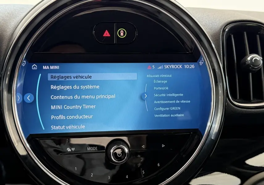 Écran tactile circulaire du système multimédia MINI Countryman 2023, affichant les réglages du véhicule.