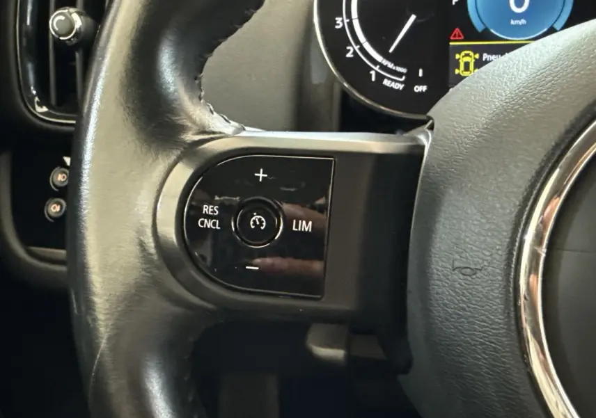 Gros plan sur le côté gauche du volant cuir noir d’un MINI Countryman 2023, avec commandes de régulateur de vitesse.