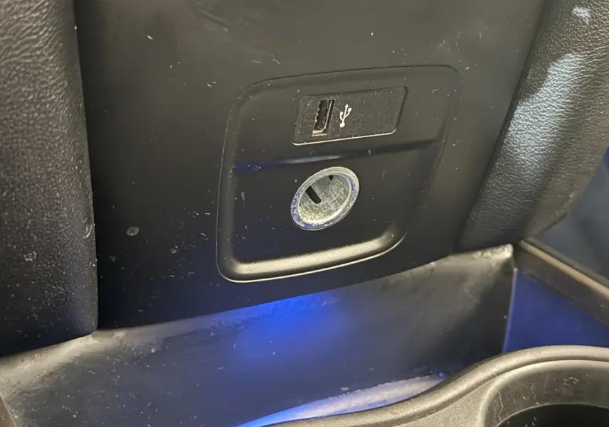 Prise USB et prise 12V en gros plan dans l’habitacle noir du MINI Countryman Cooper Essential 2023.