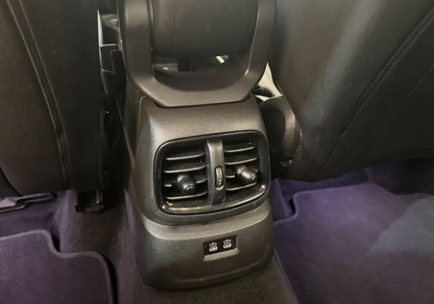 Vue rapprochée des aérateurs arrière et ports USB situés entre les sièges noirs d'un MINI Countryman gris clair.