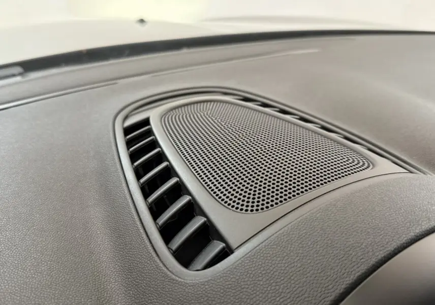 Gros plan sur la grille d’aération centrale noire du tableau de bord du MINI Countryman gris clair 2023.