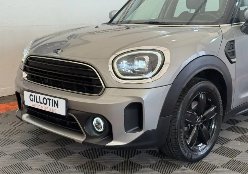 Vue 3/4 avant droit d'une MINI Countryman gris clair avec phares LED et jantes noires brillantes.