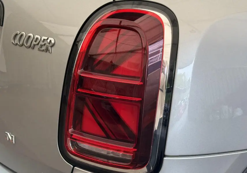 Gros plan sur le feu arrière droit rouge et le logo Cooper du MINI Countryman gris clair 2023.