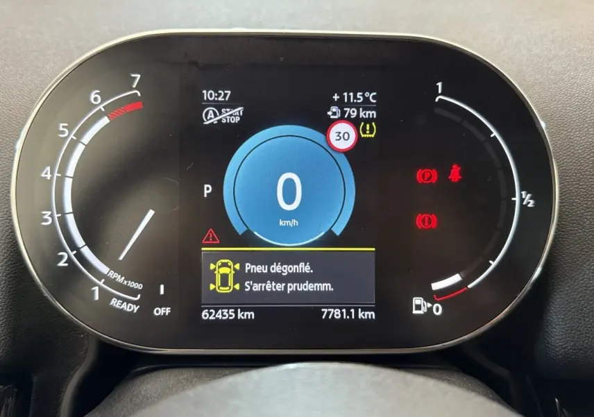 Tableau de bord numérique de MINI Countryman 2023 affichant une alerte de pneu dégonflé et la vitesse à 0 km/h.