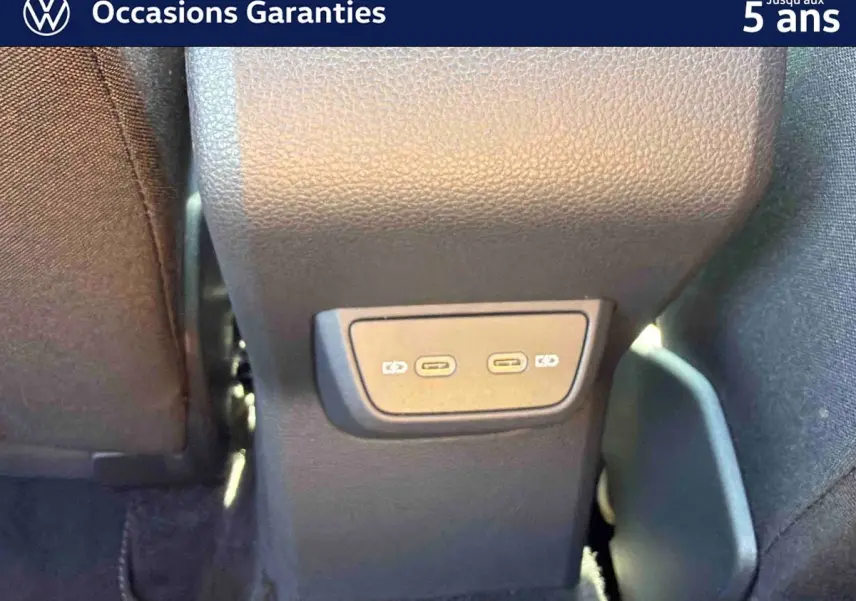 Vue rapprochée des ports USB-C arrière du Volkswagen Taigo bleu, entre les sièges avant.