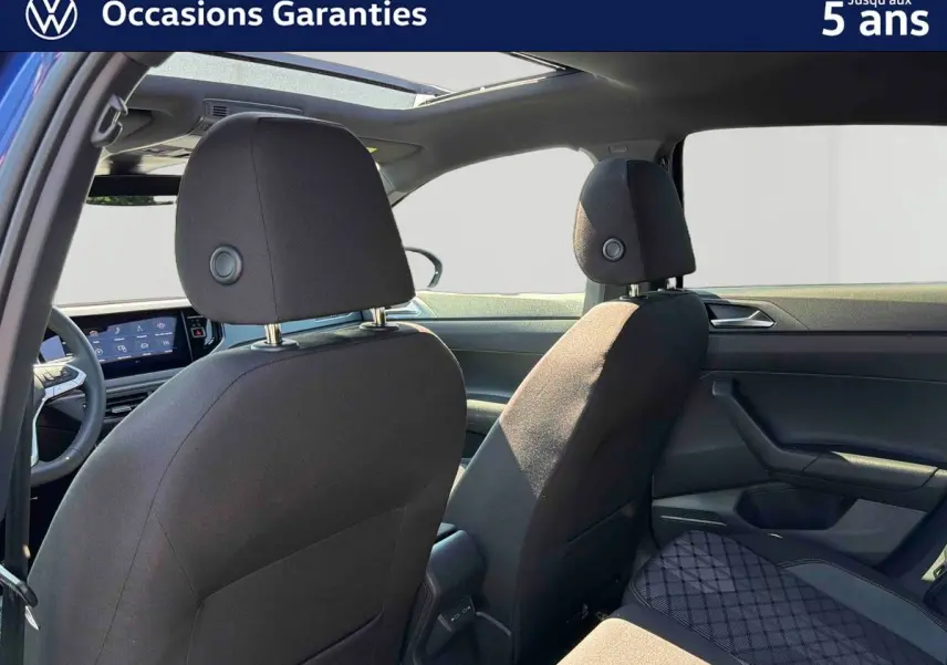 Vue intérieure arrière du Volkswagen Taigo 2025 montrant les sièges avant noirs et le toit ouvrant en verre.