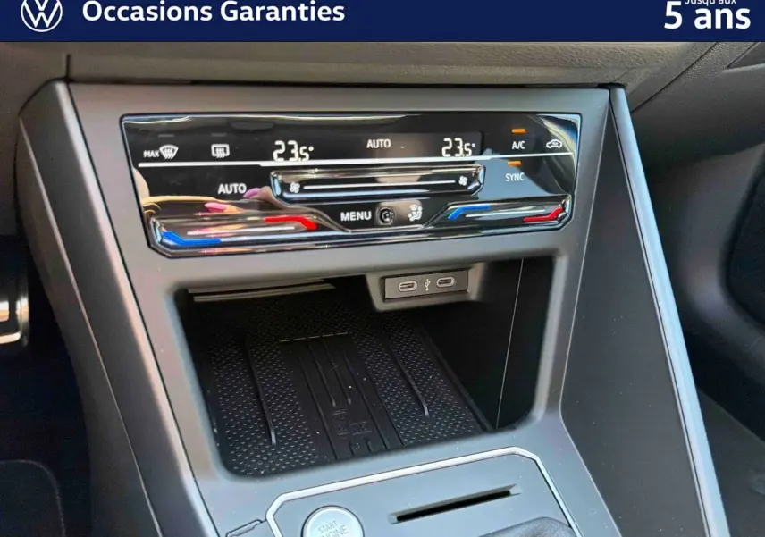 Détail de la console centrale du Volkswagen Taigo 2025, montrant la climatisation tactile bi-zone et la zone de recharge sans fil.