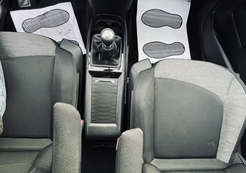 Vue plongeante sur l'intérieur avant gris et noir du Citroën C4 Picasso II avec boîte manuelle et console centrale.