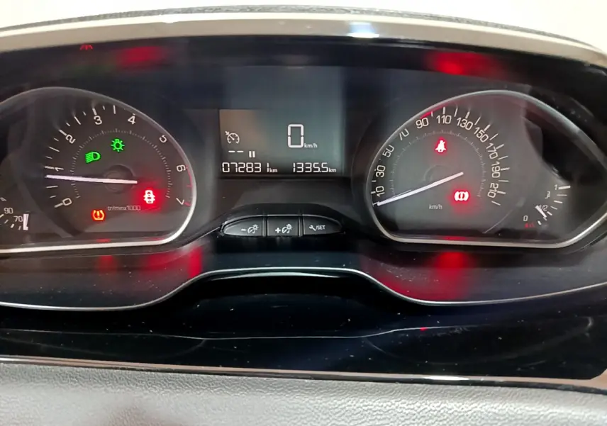 Tableau de bord de Peugeot 208 Puretech 82 Signature 2018, affichage numérique et compteurs analogiques allumés.