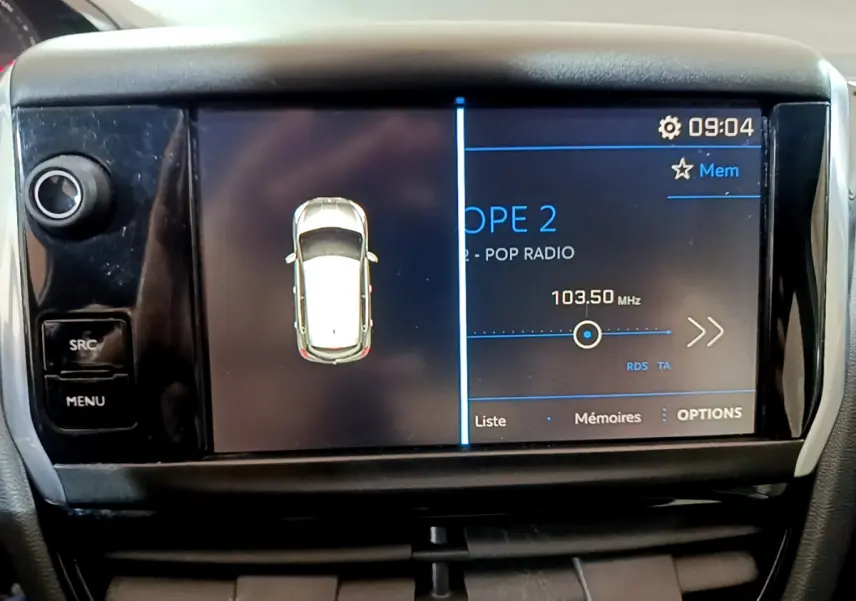 Écran tactile central de la Peugeot 208 Puretech 82 Signature affichant la radio et la vue du véhicule blanc en survol.