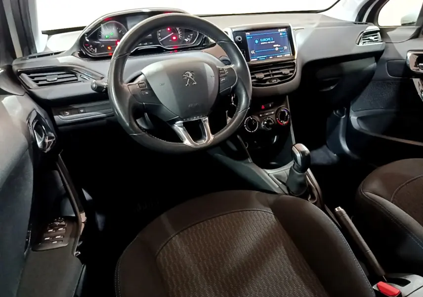 Intérieur de la Peugeot 208 Puretech 82 Signature 2018, vue côté conducteur sur volant cuir et écran tactile.