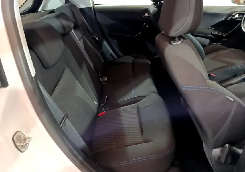 Vue intérieure côté gauche de la banquette arrière noire avec surpiqûres bleues d'une Peugeot 208 blanche Puretech 82 Signature 2018.