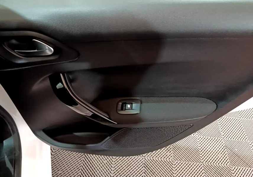 Gros plan sur la porte avant gauche noire intérieure d'une Peugeot 208 blanche Puretech 82 Signature 2018.