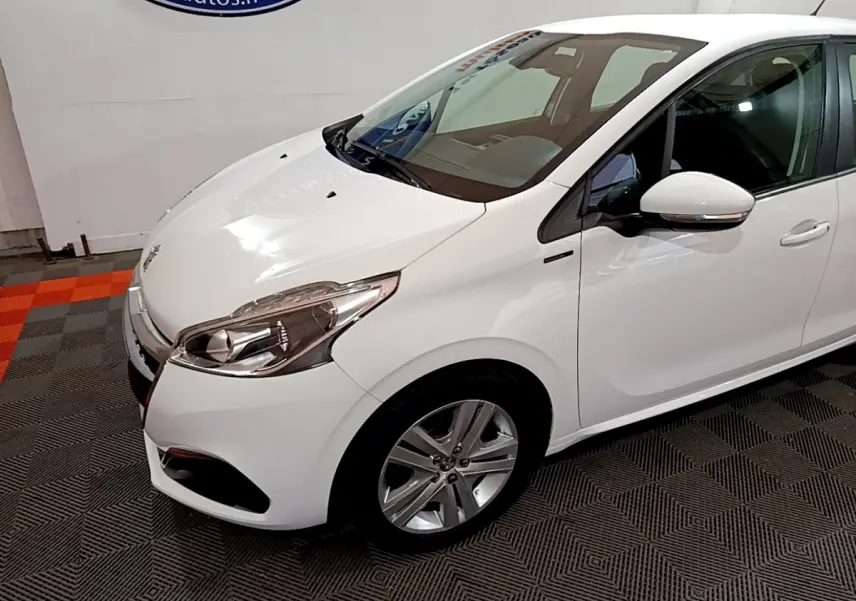 Peugeot 208 Puretech 82 Signature blanc vue 3/4 avant droit, avec phares LED et jantes alliage visibles.