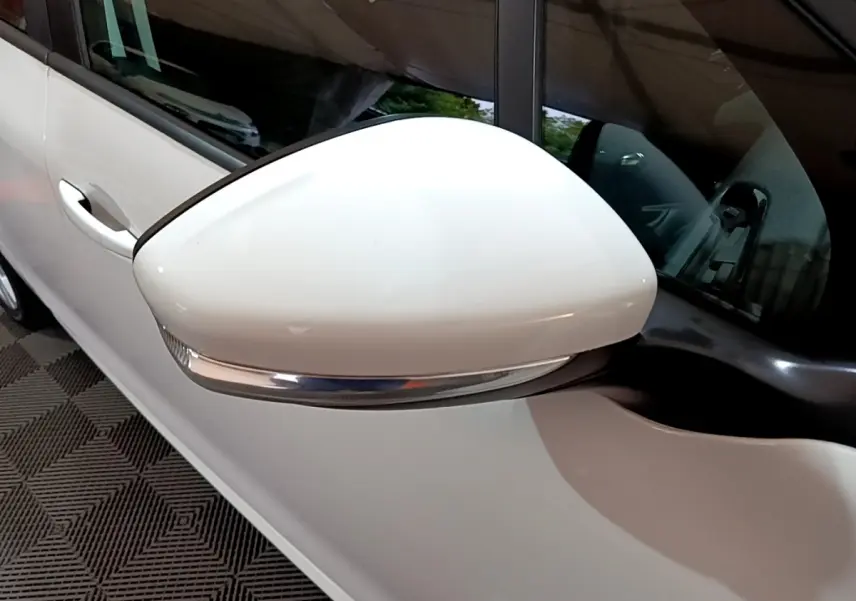 Rétroviseur droit blanc avec clignotant intégré sur une Peugeot 208 Puretech 82 Signature blanche, vue rapprochée.