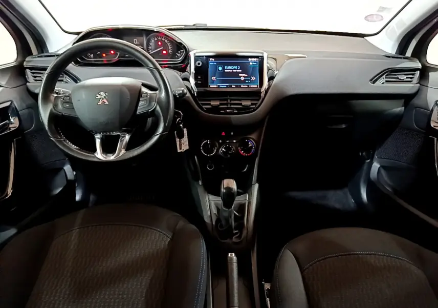 Vue intérieure frontale du tableau de bord et volant cuir noir de la Peugeot 208 Puretech 82 Signature.