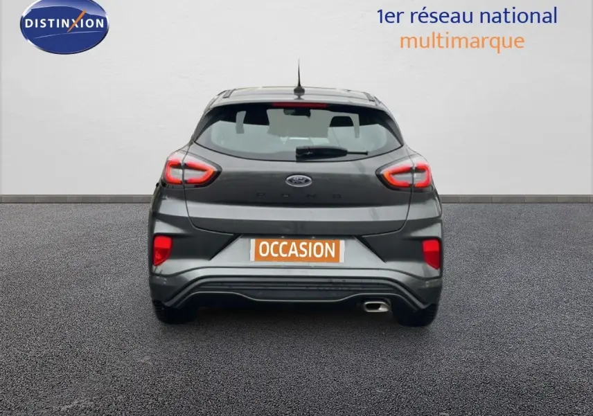 Vue arrière d'une Ford Puma gris magnetic metal 2024 avec feux LED allumés et sortie d'échappement visible côté droit.