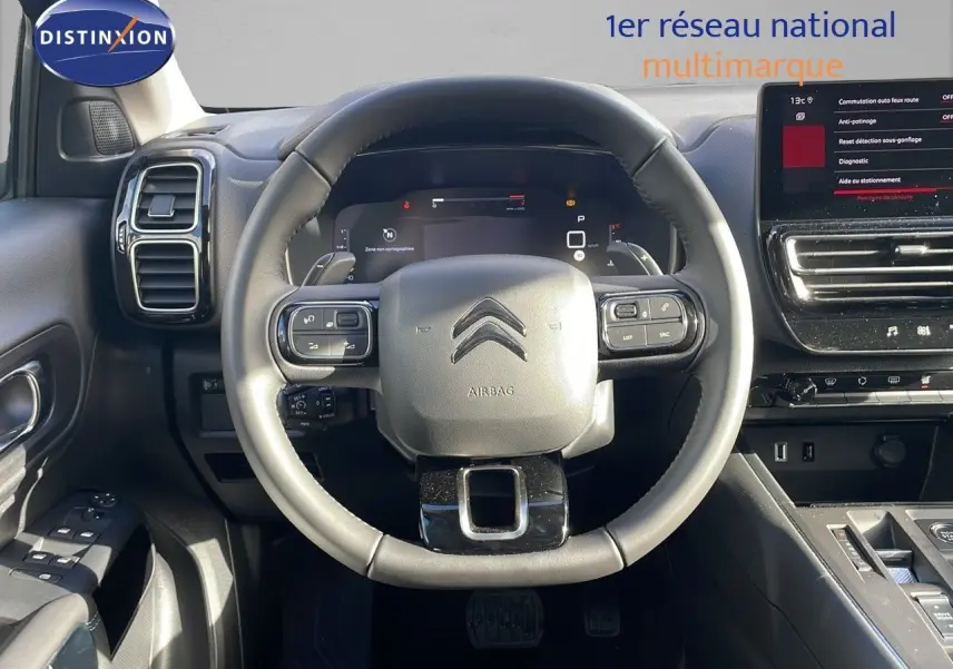Vue centrée sur le volant cuir noir du Citroën C5 Aircross 2025 avec tableau de bord numérique et écran tactile.