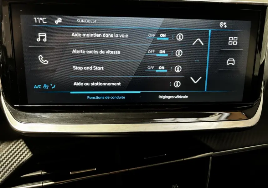 Écran tactile central affichant les réglages d'aide à la conduite dans l'habitacle d'une Peugeot 208 gris clair.