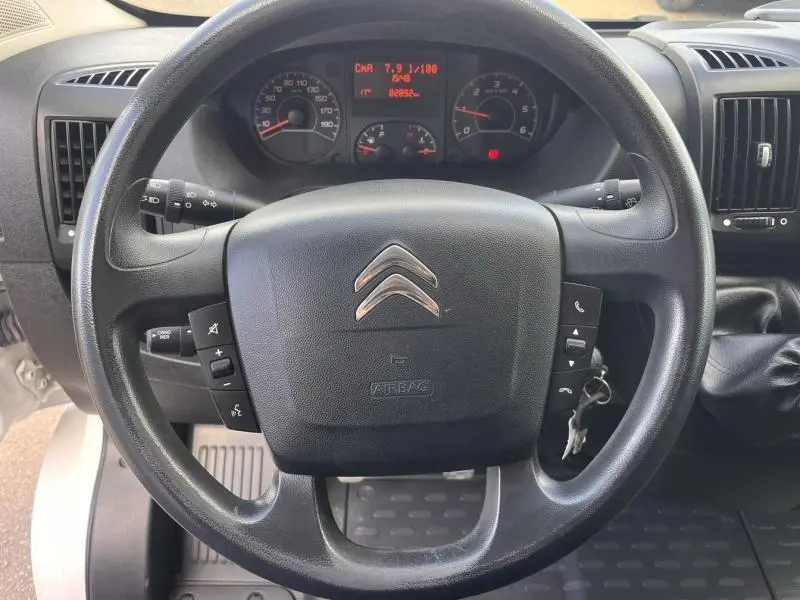 Vue rapprochée du volant multifonction noir et du tableau de bord digital du Citroën Jumper FGN blanc Icy 2021.