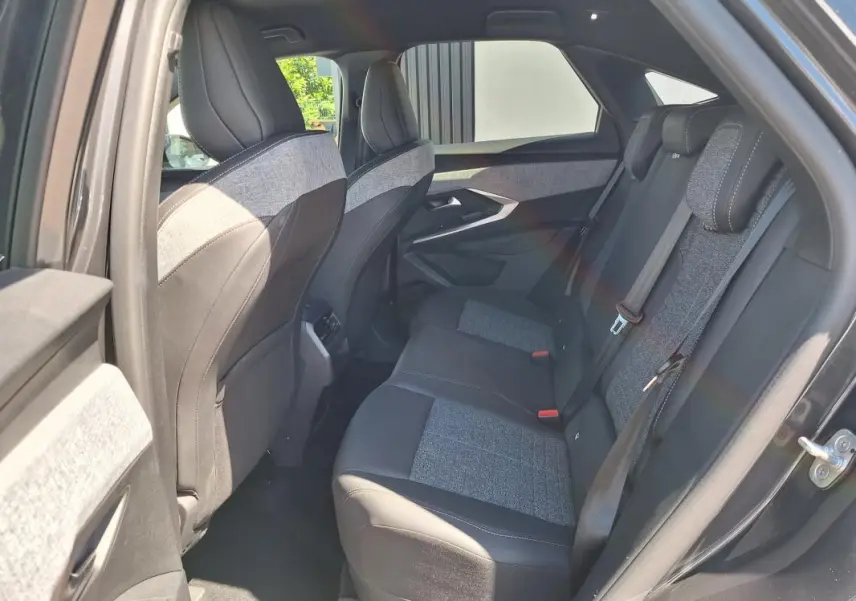 Vue intérieure côté droit des sièges arrière gris foncé mêlant tissu et cuir dans un Peugeot 3008 Hybrid 2025.