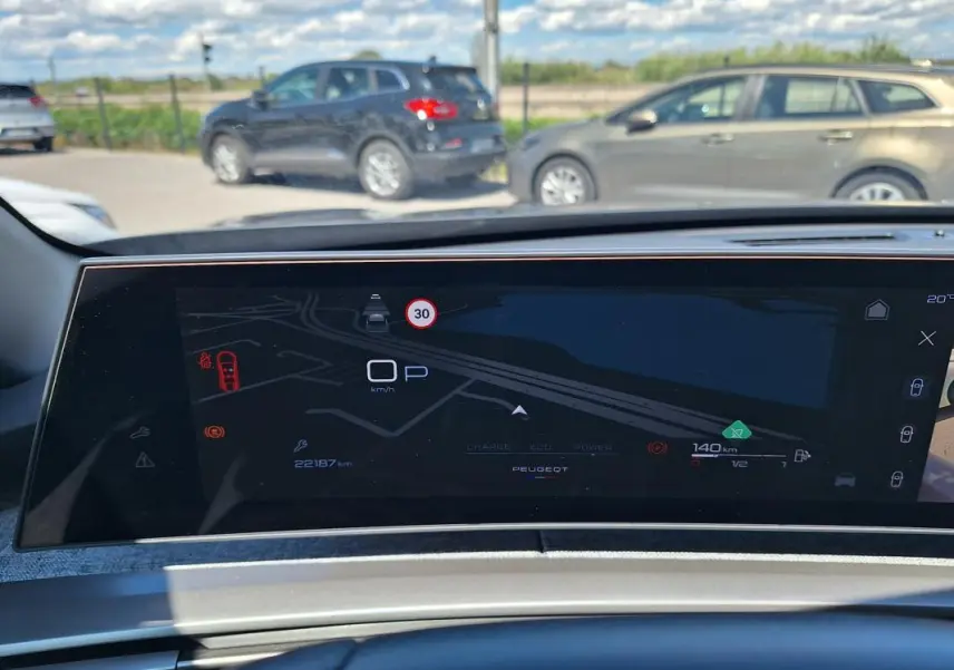Vue intérieure du cockpit numérique du Peugeot 3008 gris foncé, affichage de navigation et informations de conduite.