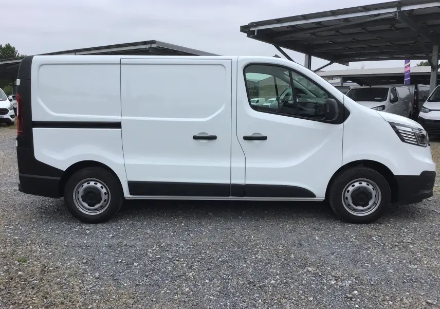 Vue de profil côté gauche d’un Renault Trafic Fourgon blanc 2024 avec portes latérales et jantes acier.