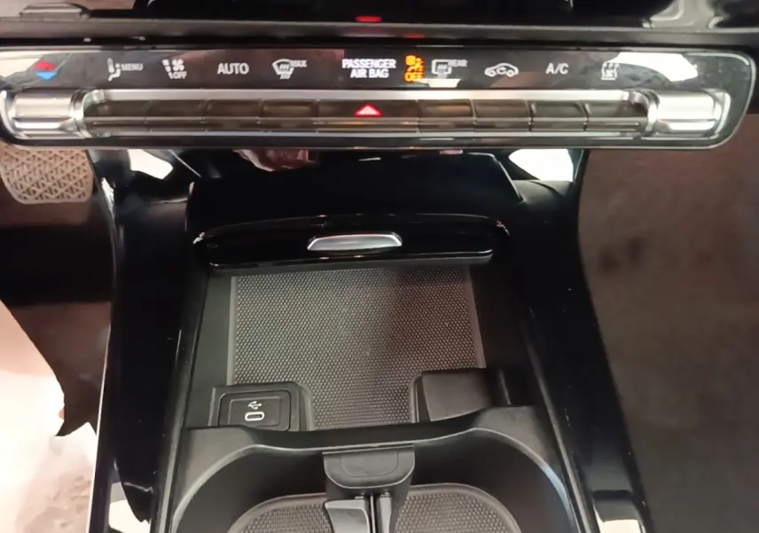 Vue rapprochée de la console centrale noire du Mercedes Classe A 250 e Business Line 2023 avec commandes climatisation et pavé tactile.